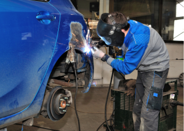 Mechanic welds a car